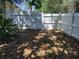 Private backyard area featuring a white picket fence and leafy ground cover at 3586 Culpepper Ter, North Port, FL 34286