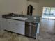 Clean kitchen with stainless steel appliances, white cabinets, and gray countertops, with a view to the pool at 3586 Culpepper Ter, North Port, FL 34286
