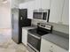 Modern kitchen featuring stainless steel appliances, white cabinetry, and sleek countertops at 3586 Culpepper Ter, North Port, FL 34286