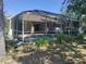 Backyard view featuring a screened-in pool, patio area, and lush greenery at 3586 Culpepper Ter, North Port, FL 34286