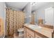 Bathroom features a shower-tub combo, vanity, and palm-themed shower curtain at 37434 Derbyshire Dr, Zephyrhills, FL 33542