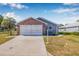Attractive single-story home with a brick-accented garage, lush lawn, and welcoming curb appeal at 37434 Derbyshire Dr, Zephyrhills, FL 33542