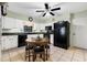 Cozy kitchen with black appliances, a black ceiling fan, and a round dining table at 37434 Derbyshire Dr, Zephyrhills, FL 33542