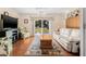 Relaxing living room features a ceiling fan, sliding glass door to the backyard, and hardwood floors at 37434 Derbyshire Dr, Zephyrhills, FL 33542