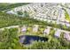 An aerial view shows a neighborhood with beautiful landscaping, mature trees, and a pond at 4111 70Th E Ave, Ellenton, FL 34222