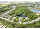 An aerial view showcasing the home's location in a peaceful community with mature trees and a pond at 4111 70Th E Ave, Ellenton, FL 34222