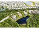 An aerial view showing well-maintained homes, lovely landscaping, mature trees, and a pond at 4111 70Th E Ave, Ellenton, FL 34222