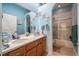 Bathroom with double vanity, wood cabinets, large mirror, and a shower at 4111 70Th E Ave, Ellenton, FL 34222