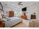 Cozy bedroom with a bed, ceiling fan, and dresser, with a TV hanging from the ceiling at 4111 70Th E Ave, Ellenton, FL 34222