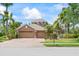 Inviting exterior with a three-car garage, surrounded by mature palms and well-maintained landscaping at 4111 70Th E Ave, Ellenton, FL 34222