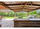Covered outdoor kitchen and dining area with a built-in grill overlooking a tranquil pond at 4111 70Th E Ave, Ellenton, FL 34222