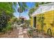Backyard featuring a stone pathway and lush garden with patio furniture and an umbrella for shade at 4462 2Nd S Ave, St Petersburg, FL 33711