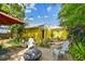 Outdoor seating area and fire pit with yellow siding in a lush backyard at 4462 2Nd S Ave, St Petersburg, FL 33711