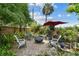 Backyard featuring a fire pit on a stone patio with seating, surrounded by lush landscaping and privacy fence at 4462 2Nd S Ave, St Petersburg, FL 33711