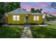 Charming yellow home featuring a cozy front porch and beautifully landscaped front yard with a sidewalk at 4462 2Nd S Ave, St Petersburg, FL 33711