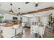 Open concept kitchen and dining area with a wooden beam, bar stools, and stainless appliances at 4462 2Nd S Ave, St Petersburg, FL 33711