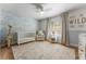 Bedroom features a crib, plush chair, and light colored wainscoting at 4677 Del Sol Blvd, Sarasota, FL 34243