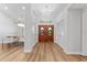 Bright foyer featuring wood flooring, a decorative chandelier, and double-door entry at 4677 Del Sol Blvd, Sarasota, FL 34243