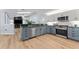 Stylish kitchen features stainless appliances, two-tone cabinets, and wood flooring at 4677 Del Sol Blvd, Sarasota, FL 34243