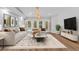 Staged living room showcasing modern décor, hardwood floors, and backyard pool view at 4677 Del Sol Blvd, Sarasota, FL 34243