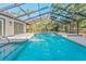 A screened-in pool with crystal-clear water is surrounded by a tiled deck with seating at 4677 Del Sol Blvd, Sarasota, FL 34243