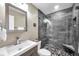 Modern bathroom with a glass-enclosed shower featuring unique pebble flooring and a gray wood-look tile surround at 4815 Plantation Dr, Tampa, FL 33615