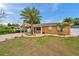 Charming single Gathering home features a well-manicured lawn, covered front porch, and mature palm trees at 4815 Plantation Dr, Tampa, FL 33615