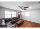 Light-filled living room with wood-look floors, a large sectional sofa, and updated ceiling fan and fixtures at 4815 Plantation Dr, Tampa, FL 33615