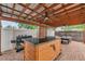 Outdoor patio space featuring a built-in bar area, seating, ceiling fans, and a well-maintained brick paver floor at 4815 Plantation Dr, Tampa, FL 33615
