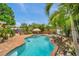 Gorgeous pool with surrounding palm trees, tiki umbrellas, spa, and patio area at 4815 Plantation Dr, Tampa, FL 33615
