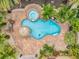 Aerial view of a backyard pool featuring a spa, tiki umbrella, and surrounding brick patio at 4815 Plantation Dr, Tampa, FL 33615