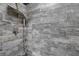 Close-up of shower stall featuring gray wood-look tile surround and rainfall shower head at 4815 Plantation Dr, Tampa, FL 33615
