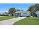 Inviting single-story home with a green lawn and a paved driveway leading to the garage at 5000 18Th S Ave, Gulfport, FL 33707