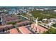 An aerial view of a condo complex with a pond, lush greenery and beautiful views of the ocean in the distance at 5033 Blue Runner Ct, New Port Richey, FL 34652