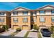 Charming multi-level condo exterior featuring a brick driveway, tan walls, dark shutters and attached garages at 5033 Blue Runner Ct, New Port Richey, FL 34652