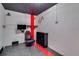 Finished game room with a striking red stripe, a wall-mounted TV, gaming chair, and dark ceiling at 5033 Blue Runner Ct, New Port Richey, FL 34652