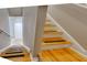Bright staircase featuring wood steps with non-slip strips, leading to a hallway with a white entry door at 5033 Blue Runner Ct, New Port Richey, FL 34652