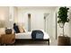 Minimalist bedroom with a plant, open closet, modern art, and a comfortable bed setup at 5619 Red Kite Dr, Wimauma, FL 33598