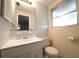 Well-lit bathroom featuring a large mirror, vanity and tiled walls at 6800 William Tell Dr, New Port Richey, FL 34653