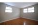 Cozy bedroom featuring hardwood floors, neutral paint and lots of natural light at 6800 William Tell Dr, New Port Richey, FL 34653