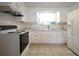 Well-lit kitchen equipped with white cabinetry, matching appliances and tile flooring at 6800 William Tell Dr, New Port Richey, FL 34653