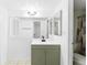 Bright bathroom with white countertops, olive green vanity, and large mirror at 7535 Abonado Rd, Tampa, FL 33615