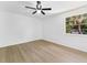 Bright bedroom with light wood floors and a ceiling fan. Includes a window with a palm tree view at 7535 Abonado Rd, Tampa, FL 33615