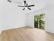 Well-lit bedroom with light wood floors, a ceiling fan and a sliding glass door with balcony at 7535 Abonado Rd, Tampa, FL 33615