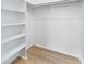 Spacious walk-in closet with light wood floors and built-in shelving at 7535 Abonado Rd, Tampa, FL 33615