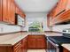 Charming kitchen with stainless steel appliances, wood cabinets, and a garden view at 7535 Abonado Rd, Tampa, FL 33615