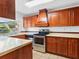 Well-equipped kitchen featuring wood cabinetry and stainless steel appliances at 7535 Abonado Rd, Tampa, FL 33615