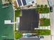 Bird's eye view showcases a modern home with a dark roof, backyard pool, and waterfront access with a private dock at 7974 1St S Ave, St Petersburg, FL 33707