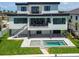 Modern home features backyard pool, two balconies, and stairs to grassy area at 7974 1St S Ave, St Petersburg, FL 33707