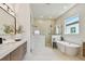 Modern bathroom featuring dual showers, soaking tub, and sleek vanity at 7974 1St S Ave, St Petersburg, FL 33707